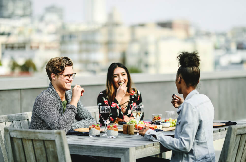 Photo of group of people on a rooftop deck enjoying the best outdoor dining in San Francisco
